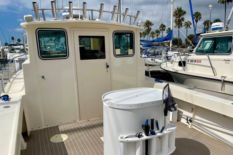 Slide: The Image of 2002 Parker 2520 XL Sport Cabin boat docked at marina, featuring fishing equipment. - 8