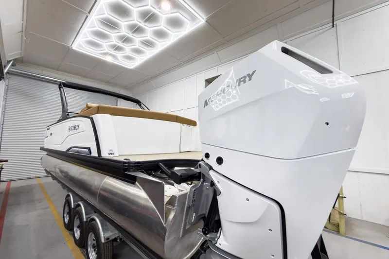 Slide: The Image of 2026 Godfrey Sanpan 27' Tritoon with Mercury engine in a showroom. - 10