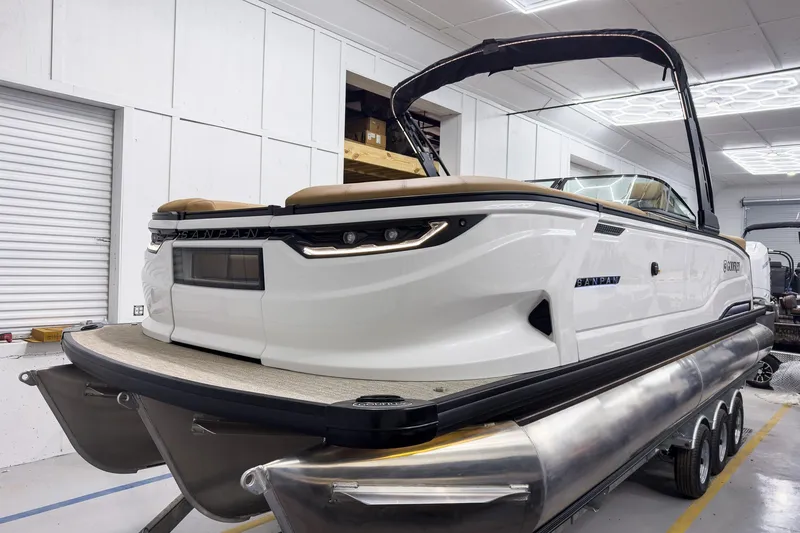 Slide: The Image of 2026 Godfrey Sanpan 27' Tritoon boat in showroom, featuring sleek design and modern amenities. - 13
