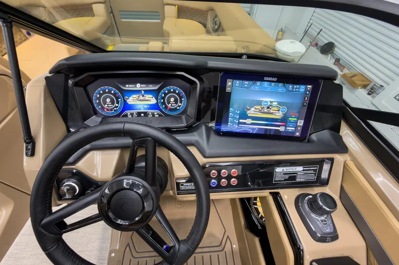 Slide: The Image of 2026 Godfrey Sanpan 27' Tritoon dashboard with advanced digital controls and steering wheel. - 25
