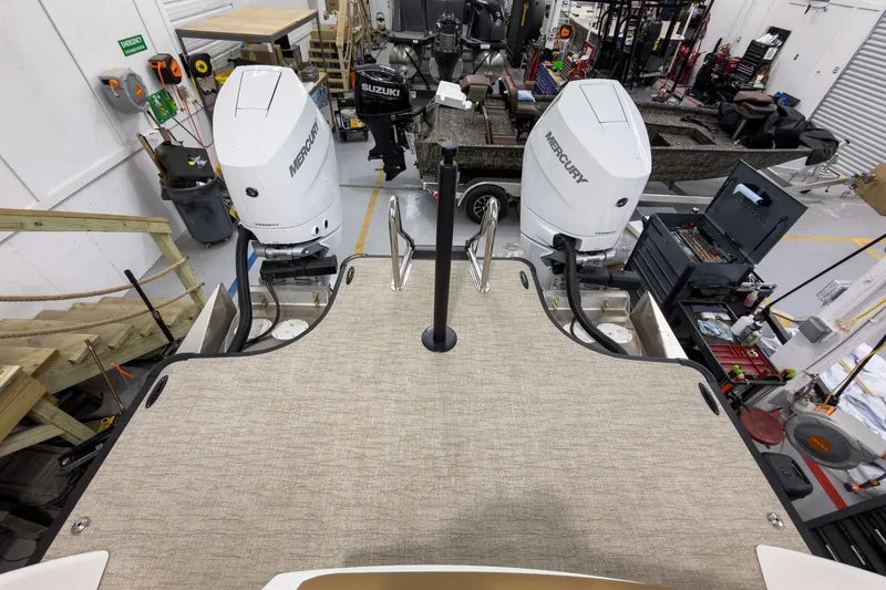 Slide: The Image of 2026 Godfrey Sanpan 27' Tritoon with twin Mercury outboard engines in a workshop setting. - 42