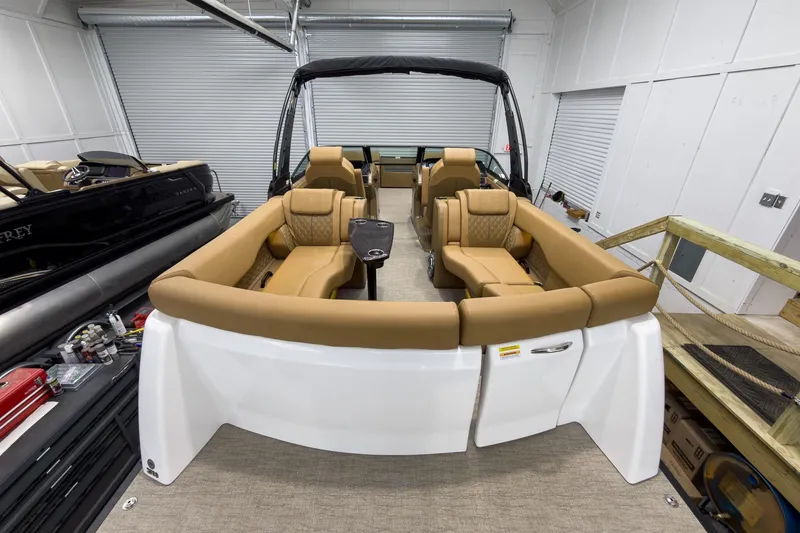 Slide: The Image of 2026 Godfrey Sanpan 27' Tritoon with luxurious tan seating in a showroom. - 44