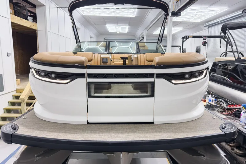 Slide: The Image of 2026 Godfrey Sanpan 27' Tritoon with luxurious seating in a showroom. - 5