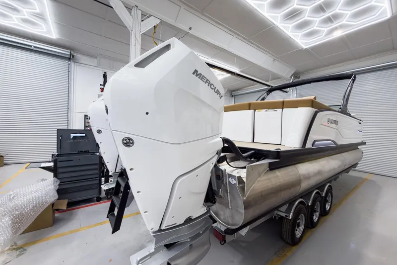 Slide: The Image of 2026 Godfrey Sanpan 27' Tritoon with Mercury engine in a showroom. - 7