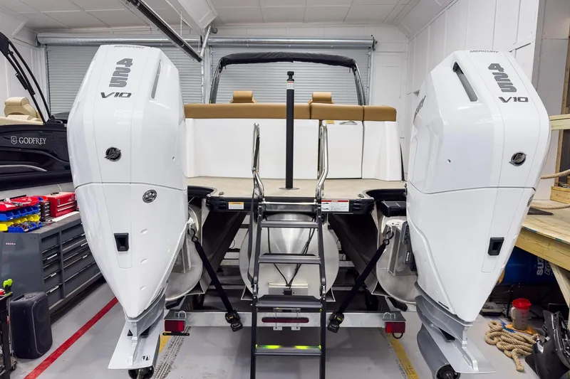 Slide: The Image of 2026 Godfrey Sanpan 27' Tritoon with twin Mercury 425 V10 engines in a garage setting. - 8