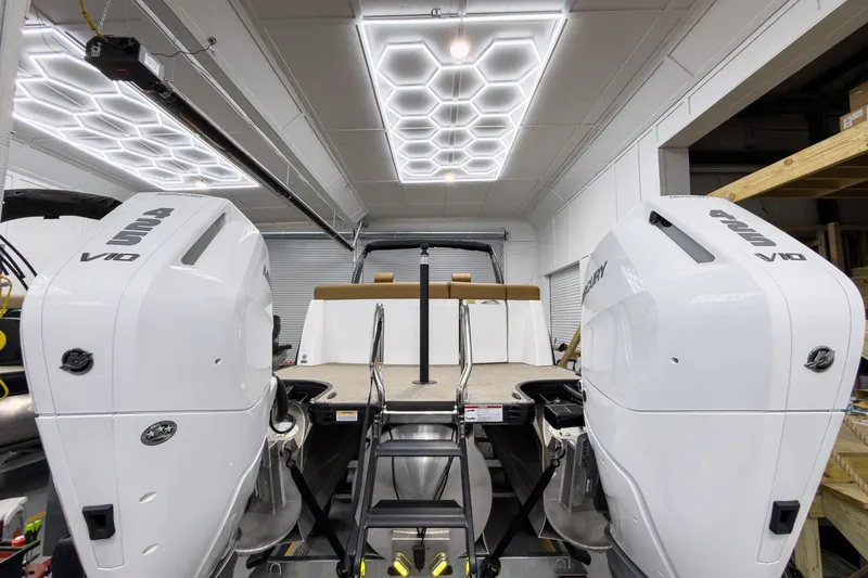 Slide: The Image of 2026 Godfrey Sanpan 27' Tritoon with twin Mercury V10 engines in a modern showroom. - 9