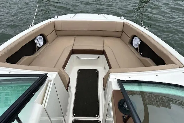 Slide: The Image of 2016 Sea Ray 220 Sundeck boat interior with beige seating, on calm water. - 3