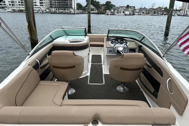 Slide: The Image of 2016 Sea Ray 220 Sundeck boat interior with tan seating, steering wheel, and water view. - 4