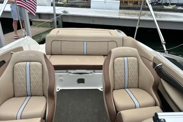 Slide: The Image of 2016 Sea Ray 220 Sundeck interior with beige seating and American flag. - 6