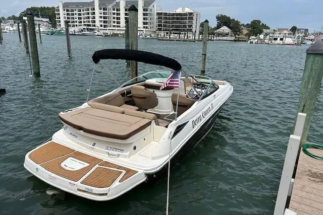 Slide: The Image of 2016 Sea Ray 220 Sundeck boat docked in marina with American flag. - 9