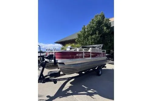 The Image of 2022 Sun Tracker Bass Buggy 18 DLX pontoon boat on trailer, parked outdoors. - 1