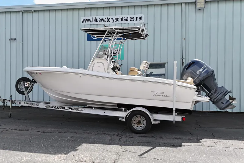 Slide: The Image of 2014 Pioneer 197 Islander boat on trailer, displayed outside Bluewater Yacht Sales. - 0