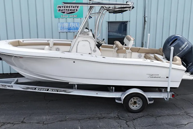 Slide: The Image of 2014 Pioneer 197 Islander boat on trailer, parked near a building with Yamaha signage. - 1