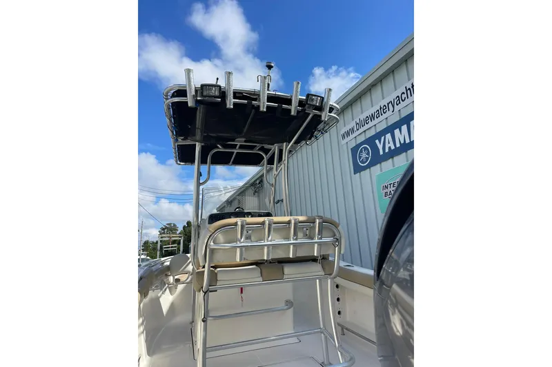 Slide: The Image of 2014 Pioneer 197 Islander boat with T-top and rod holders, parked near Yamaha sign. - 11