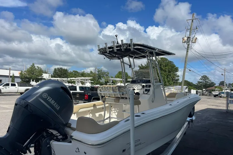 Slide: The Image of 2014 Pioneer 197 Islander boat with Yamaha engine, parked outdoors under a cloudy sky. - 13