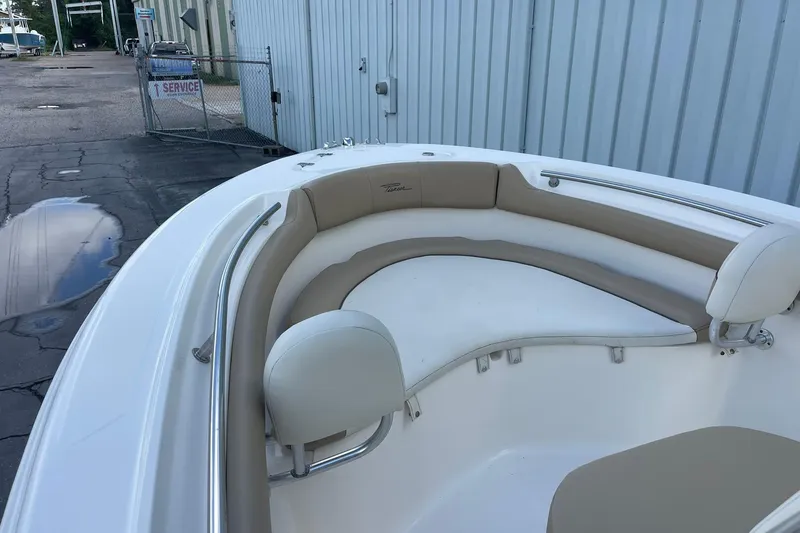 Slide: The Image of 2014 Pioneer 197 Islander boat with beige seating, docked near a service area. - 16