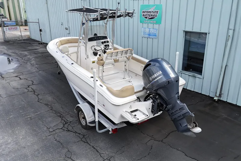 Slide: The Image of 2014 Pioneer 197 Islander boat with Yamaha engine on trailer, parked near building. - 5