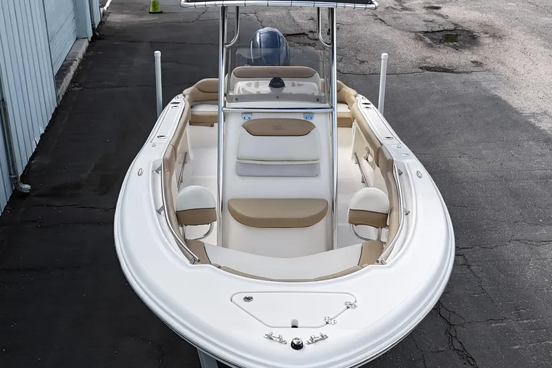 Slide: The Image of 2014 Pioneer 197 Islander boat with beige seating, docked on asphalt. - 6