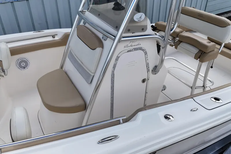 Slide: The Image of 2014 Pioneer 197 Islander boat interior with beige seating and console. - 7