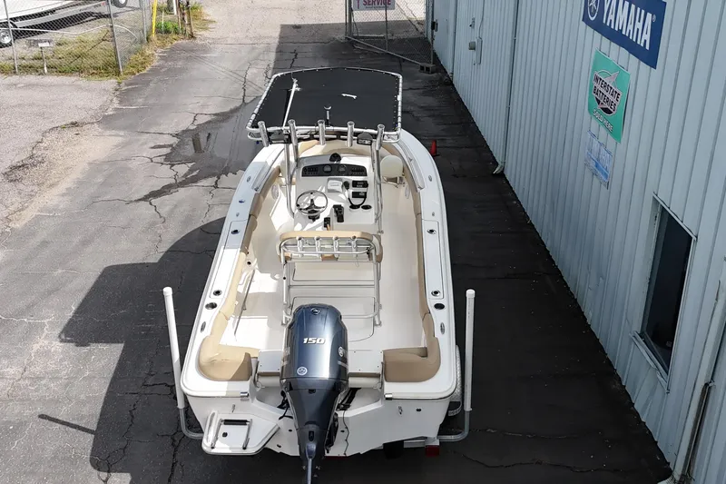 Slide: The Image of 2014 Pioneer 197 Islander boat with Yamaha 150 engine, parked near a building. - 8