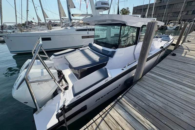 Slide: The Image of 2025 Axopar 29 XC Cross Cabin boat docked at marina, featuring sleek design and modern amenities. - 10