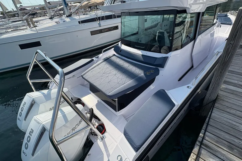 Slide: The Image of 2025 Axopar 29 XC Cross Cabin boat docked with twin Mercury engines. - 11