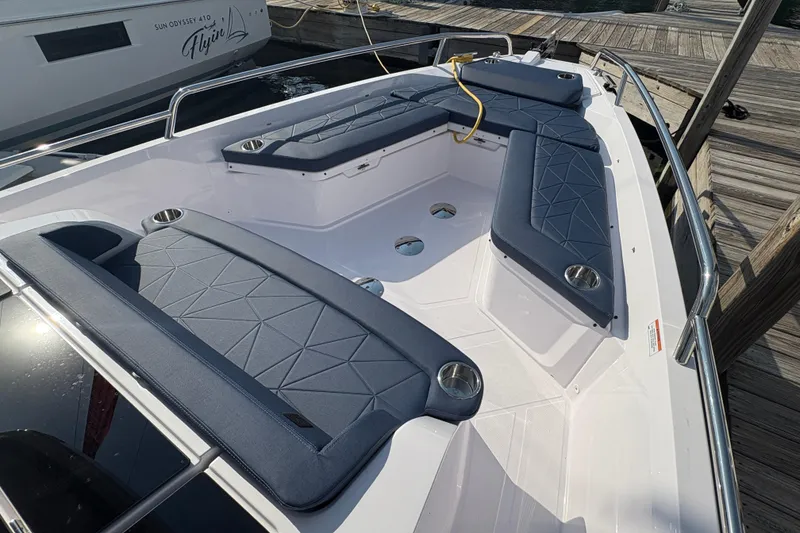 Slide: The Image of 2025 Axopar 29 XC Cross Cabin boat with cushioned seating and cup holders at dock. - 12
