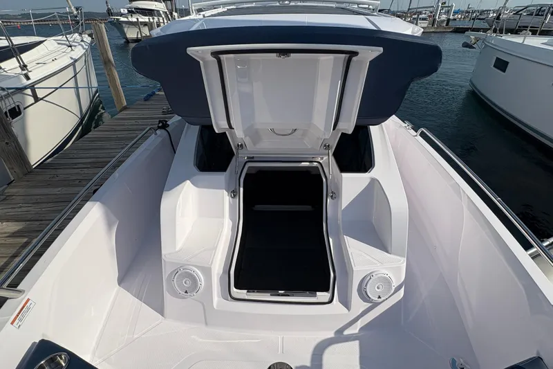 Slide: The Image of 2025 Axopar 29 XC Cross Cabin boat with open storage compartment at marina. - 15