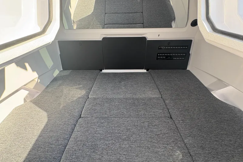 Slide: The Image of 2025 Axopar 29 XC Cross Cabin interior with gray cushioned seating and large windows. - 16