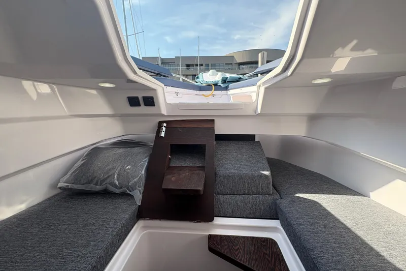 Slide: The Image of Interior of 2025 Axopar 29 XC Cross Cabin with gray seating and wooden accents. - 19