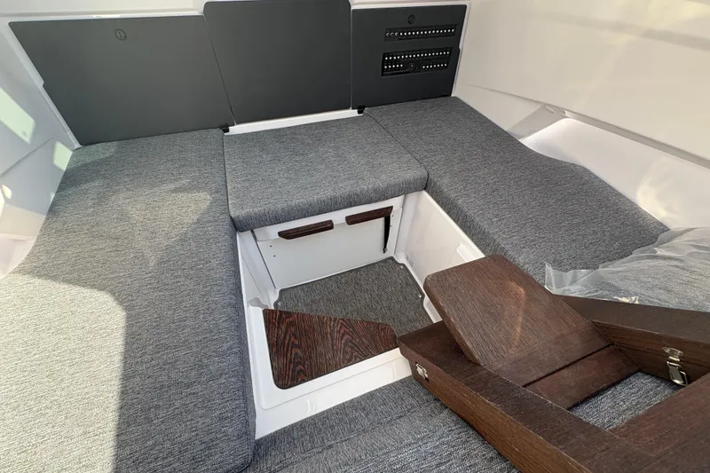 Slide: The Image of 2025 Axopar 29 XC Cross Cabin interior with gray seating and wooden accents. - 22