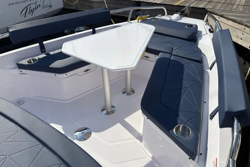 Slide: The Image of 2025 Axopar 29 XC Cross Cabin boat interior with navy seating and white table. - 29