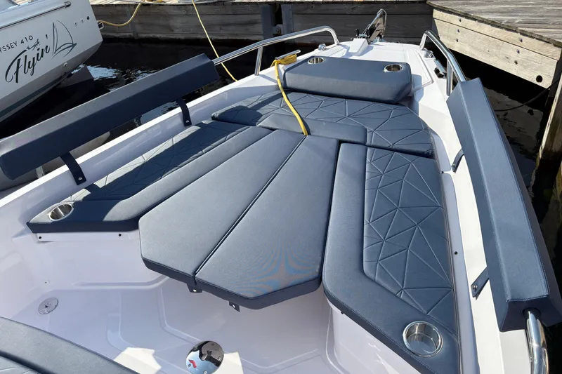 Slide: The Image of 2025 Axopar 29 XC Cross Cabin boat with stylish blue seating and cup holders. - 31