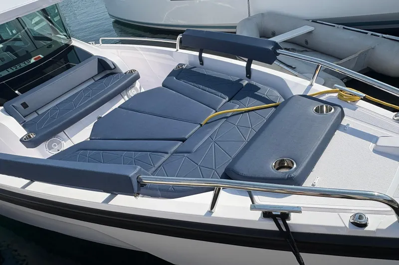 Slide: The Image of 2025 Axopar 29 XC Cross Cabin boat with blue cushioned seating and stainless steel railings. - 33
