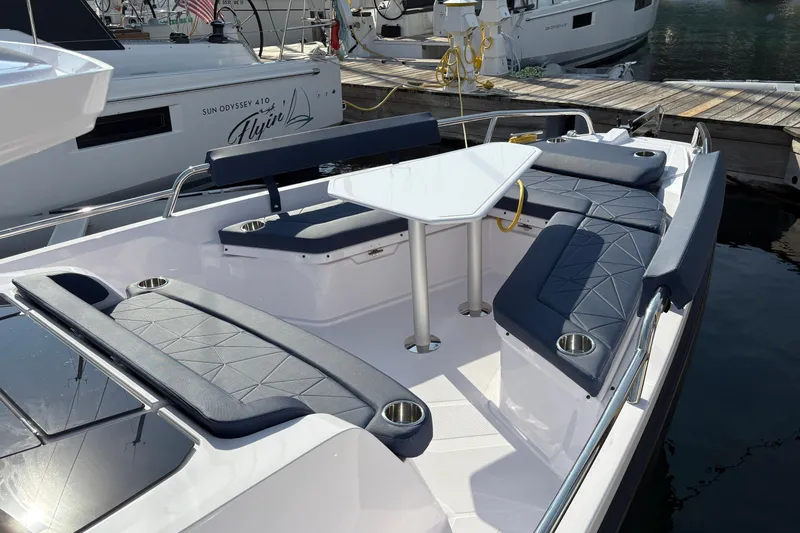 Slide: The Image of 2025 Axopar 29 XC Cross Cabin boat with sleek seating and table setup. - 45