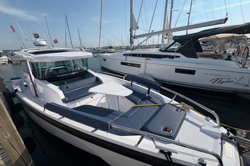 Slide: The Image of 2025 Axopar 29 XC Cross Cabin boat docked at marina, sleek design, sunny day. - 48