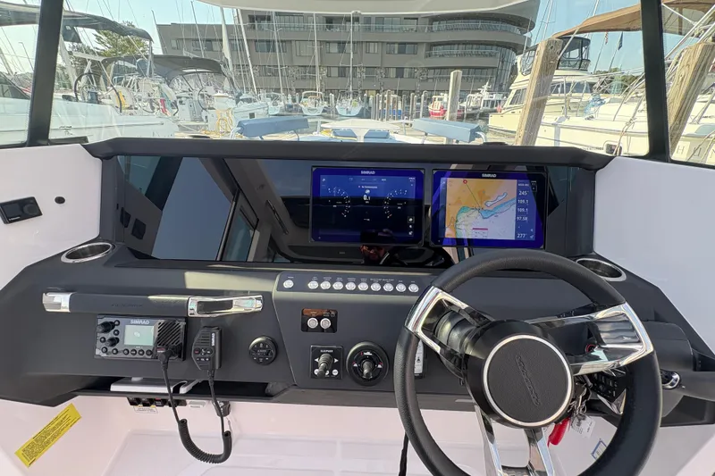 Slide: The Image of 2025 Axopar 29 XC Cross Cabin dashboard with navigation screens and steering wheel. - 52