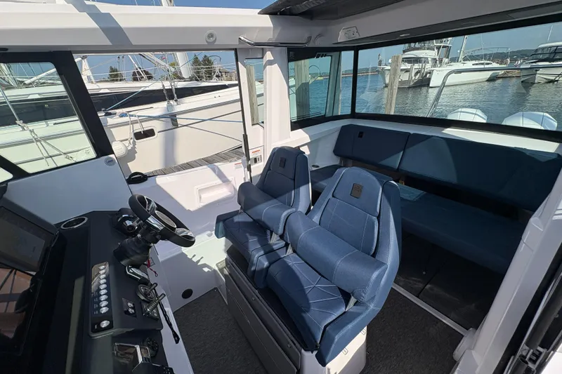 Slide: The Image of 2025 Axopar 29 XC Cross Cabin interior with blue seating and modern helm. - 56