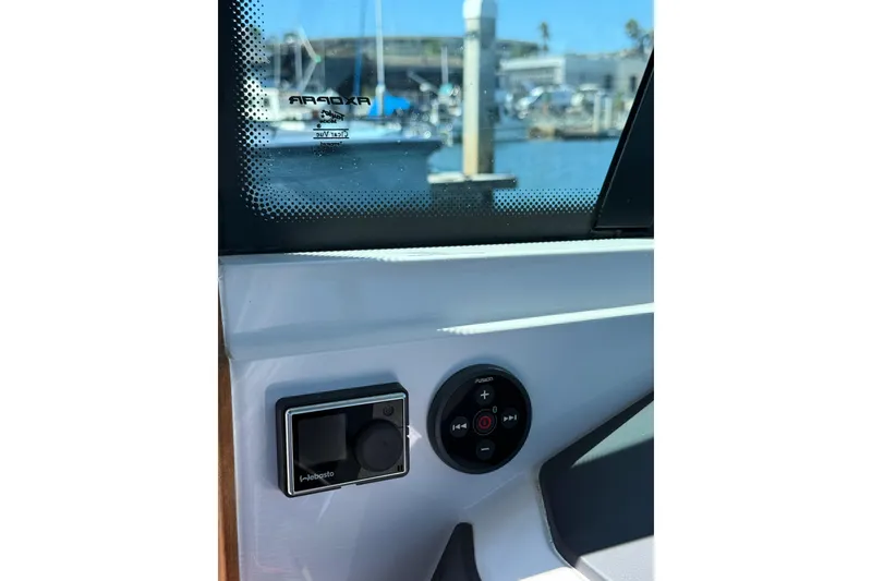 Slide: The Image of 2021 Axopar 28 Cabin BRABUS Trim interior controls with marina view. - 10