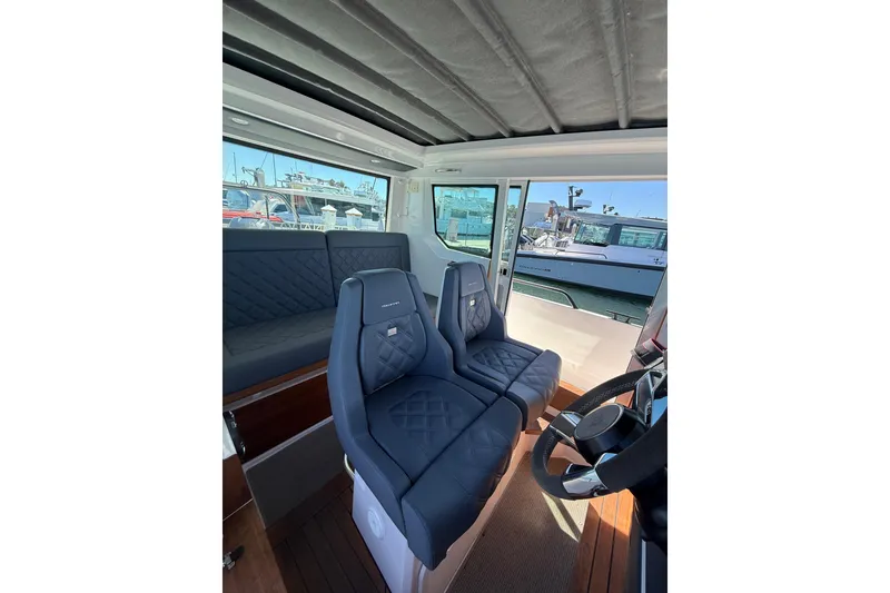 Slide: The Image of 2021 Axopar 28 Cabin BRABUS Trim interior with luxurious seating and wet bar. - 7