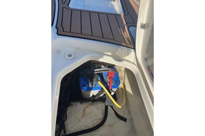 Slide: The Image of 2018 Sea Ray 21 SPX OB boat battery compartment with visible wiring and flooring. - 8