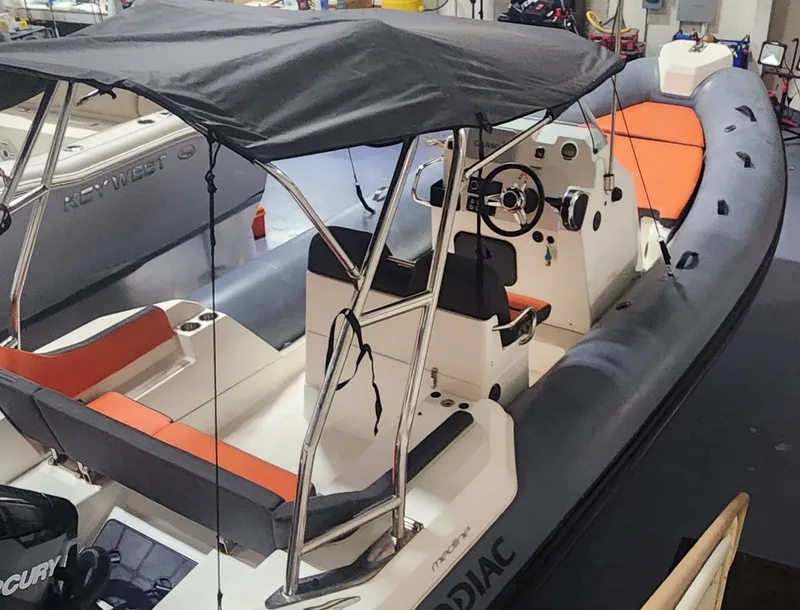 Slide: The Image of 2024 Zodiac Medline 6.8 inflatable boat with black canopy and orange seating. - 3