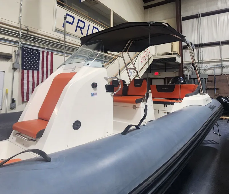 Slide: The Image of 2024 Zodiac Medline 6.8 boat in a warehouse with American flag. - 6