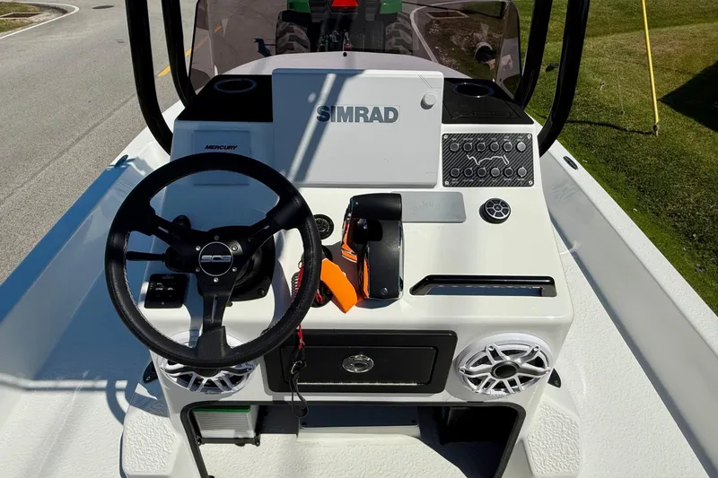 Slide: The Image of 2024 SCB S22 boat console with steering wheel, Simrad display, and Mercury controls. - 10