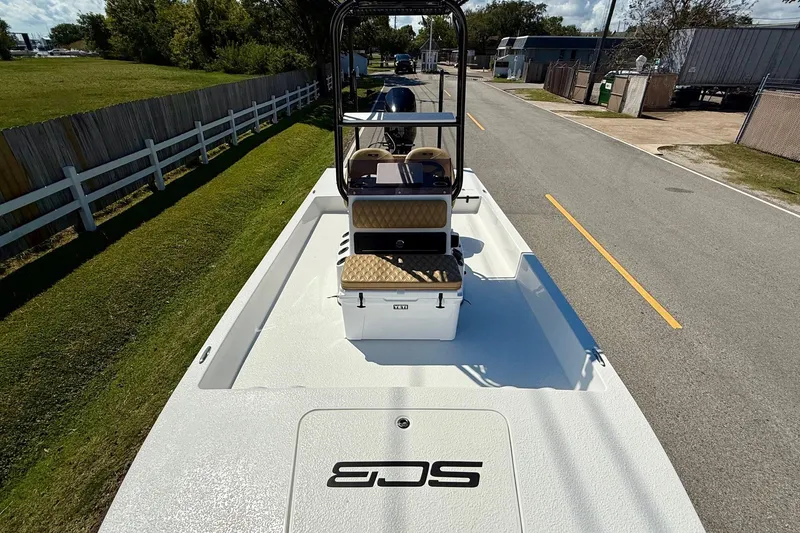 Slide: The Image of 2024 SCB S22 boat on trailer, parked on a road, showcasing sleek design and seating. - 15