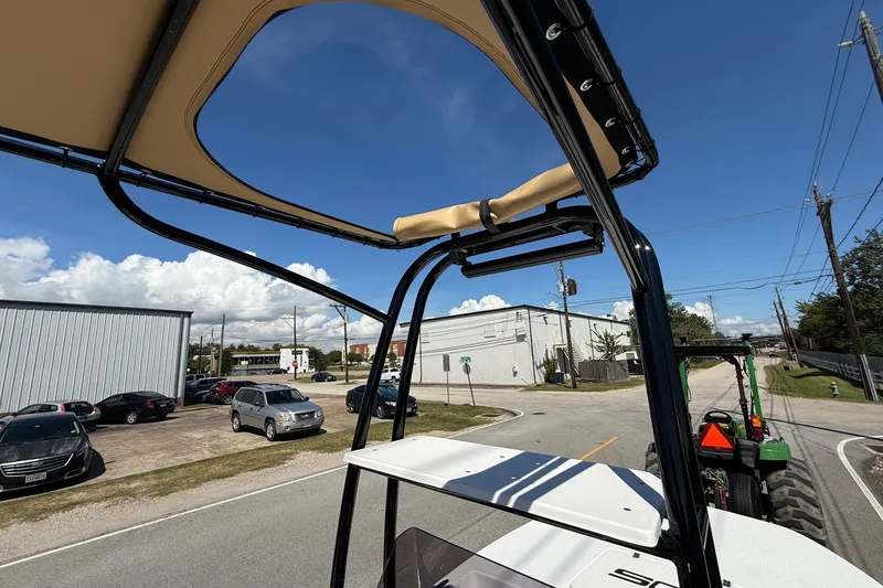 Slide: The Image of 2024 SCB S22 boat with T-top, parked near industrial buildings under a clear sky. - 19