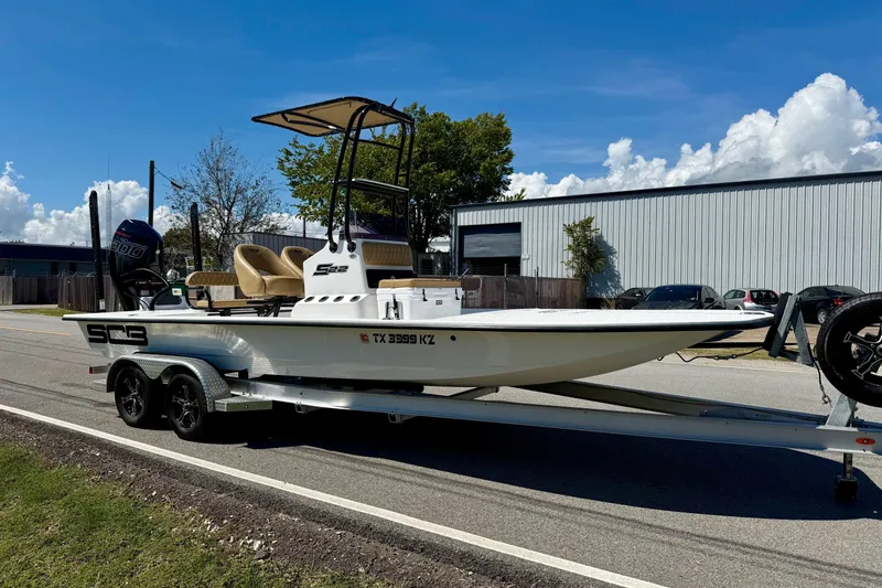 Slide: The Image of 2024 SCB S22 boat on trailer, parked on roadside under clear blue sky. - 5