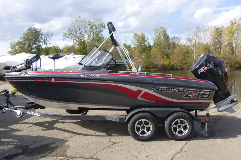 Slide: The Image of 2023 Nitro ZV19 Sport Pro boat on trailer, parked near a lake. - 1