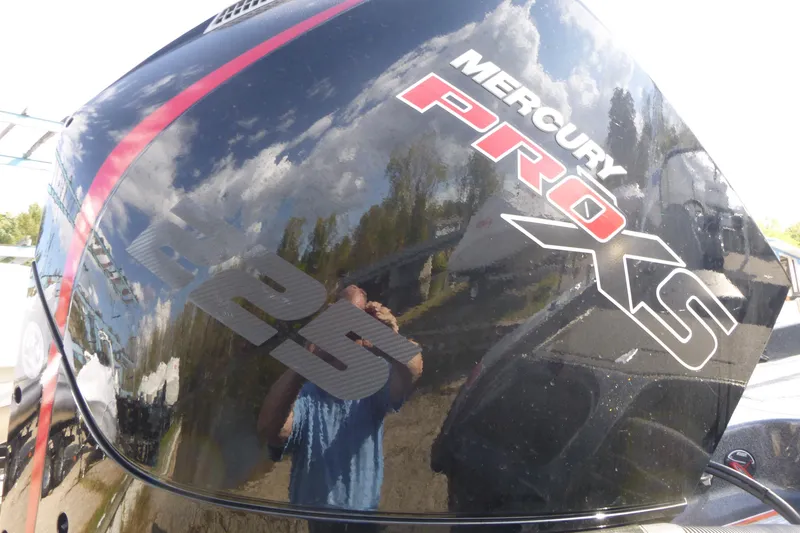 Slide: The Image of Mercury Pro XS engine on 2023 Nitro ZV19 Sport Pro boat, reflecting sky and trees. - 20