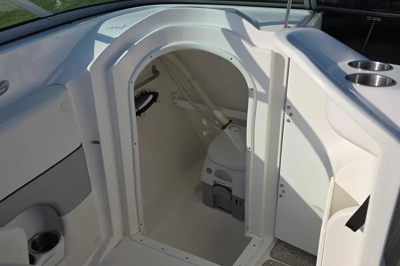 Slide: The Image of 2013 Rinker 276 Captiva Bowrider interior with compact marine toilet. - 16